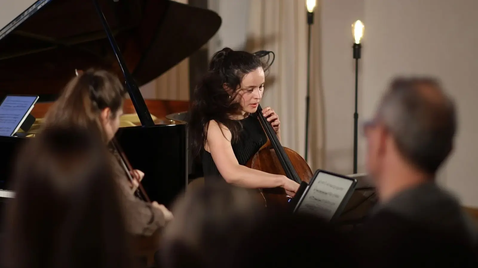 Drei Musiker*innen mit Instrumenten und Notenblatt, im Hintergrund ein Konzertflügel, zur Veranstaltung 1001 Nacht
