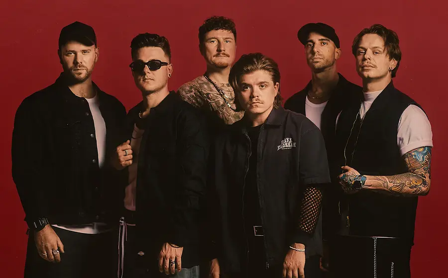 Foto für die Veranstaltung "OUR PROMISE – FEARLESS TOUR 2026" mit der Band vor rotem Hintergrund.