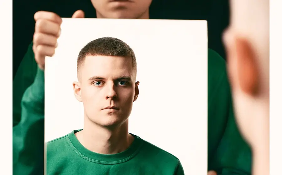 Foto für die Veranstaltung Alex Stoldt – QUASI NICHTS mit dem Künstler in einem grünen Hoodie