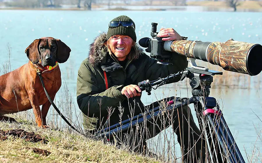 Andreas Kieling mit Hund und Fernglas in der Natur