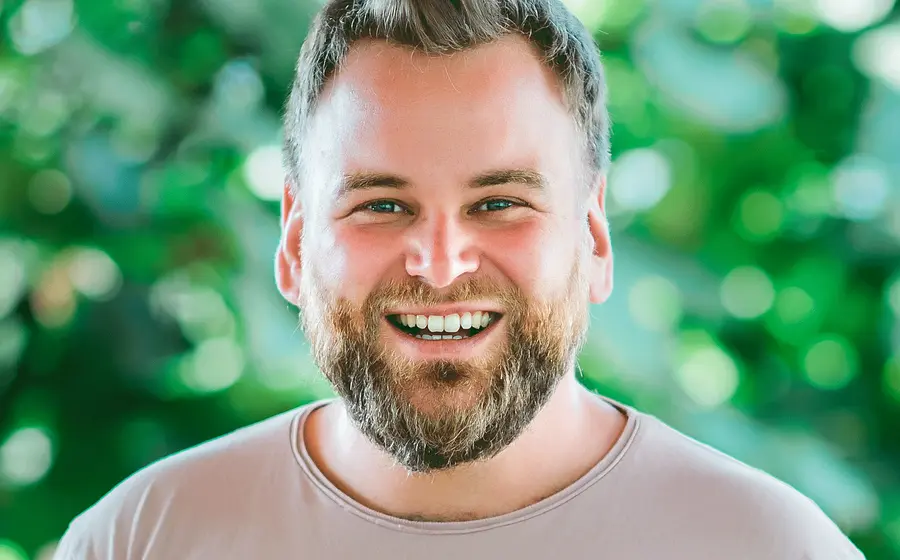 Ein Portrait vom Künstler Andre Haedicke vor grünem Hintergrund