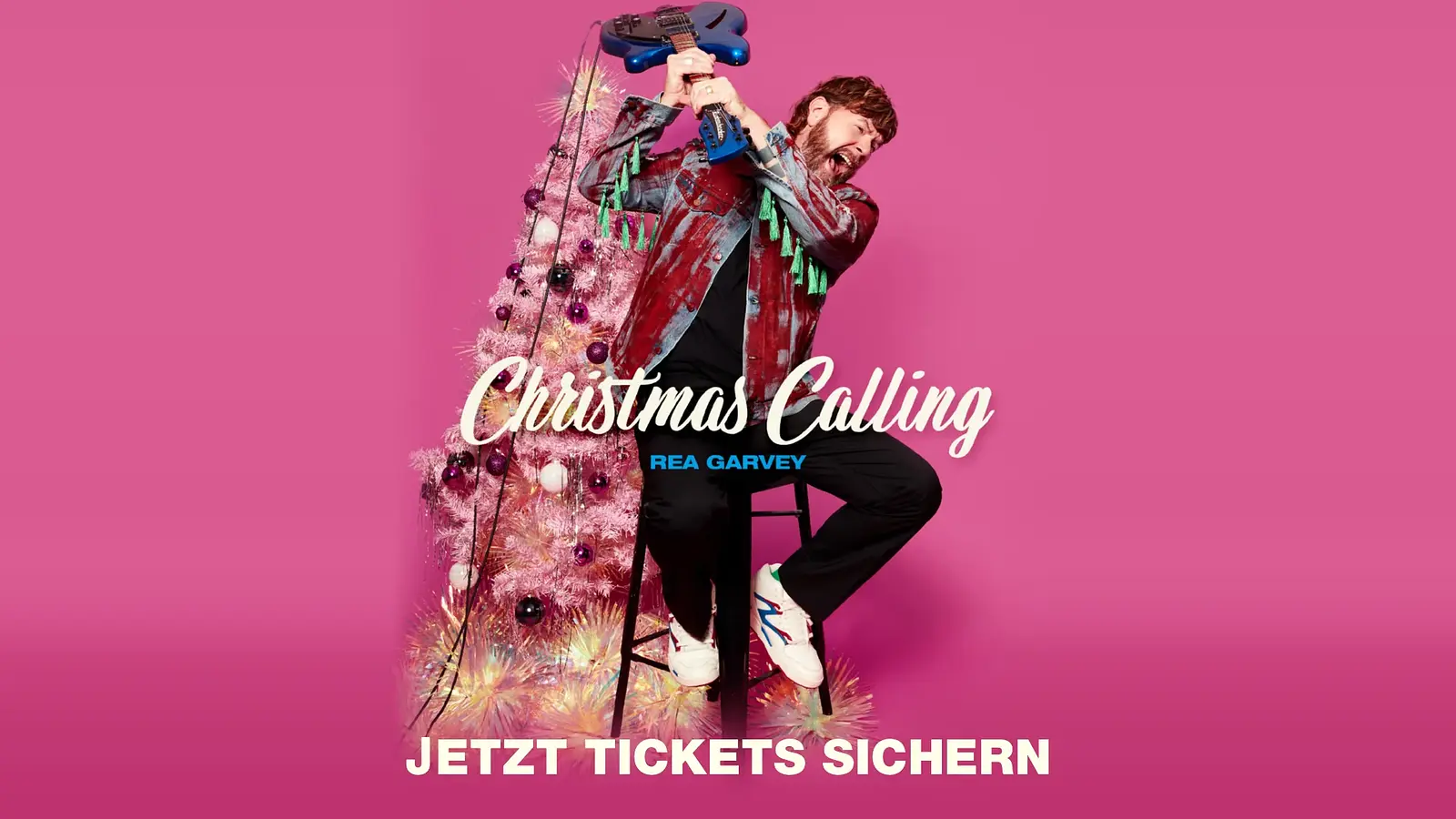 Plakat Christmas Calling von Rea Garvey mit rosa Weihnachtsbaum im Hintergrund, während Rea Garvey auf einem Hocker sitzt und eine blaue E-Gitarre über dem Kopf hält, vor pinkem Hintergrund mit dem Schriftzug Christmas Calling