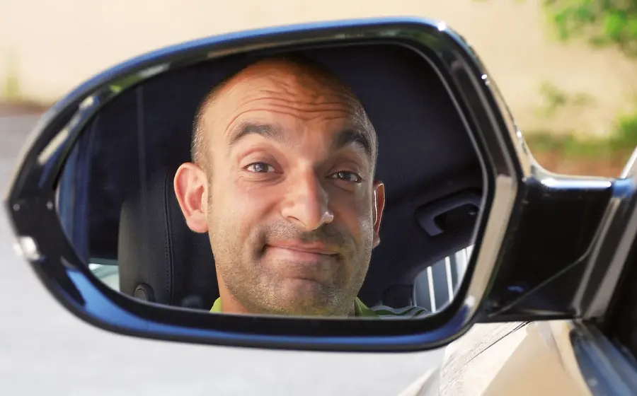 Der Künstler in einem Rückspiegel eines Autos
