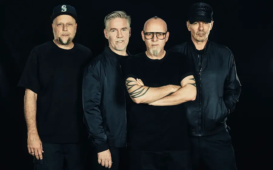 Die Fantastischen Vier vor einem schwarzen Hintergrund in schwarzer Kleidung