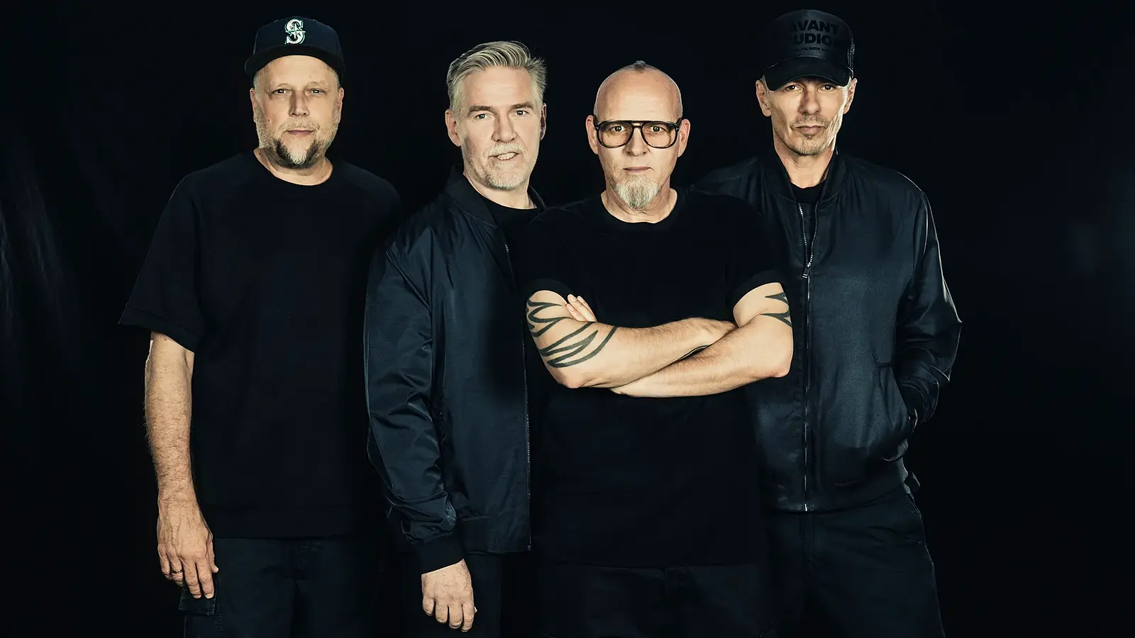 Die Fantastischen Vier vor einem schwarzen Hintergrund in schwarzer Kleidung