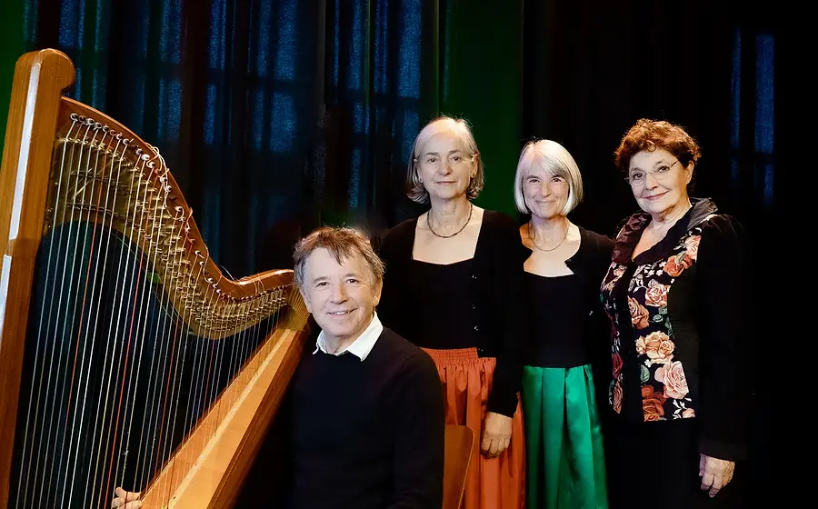 Vier Musikerinnen und ein Musiker in einem Bühnenporträt mit Harfe: Ensemble Die Wellküren und Gerhard Polt vor dunklem Hintergrund, gemeinsam posierend.