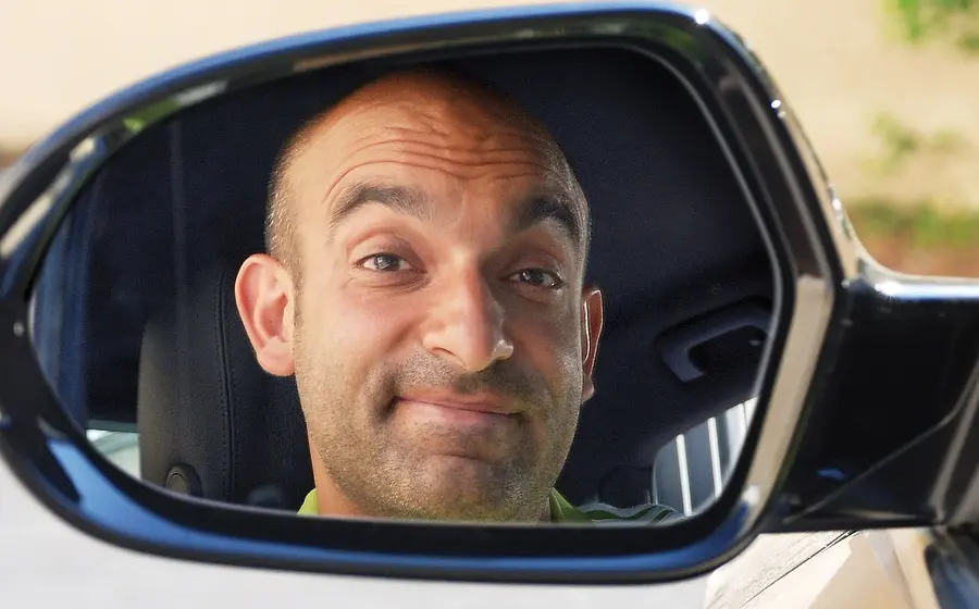 Django Asül reflektiert in einem Autospiegel