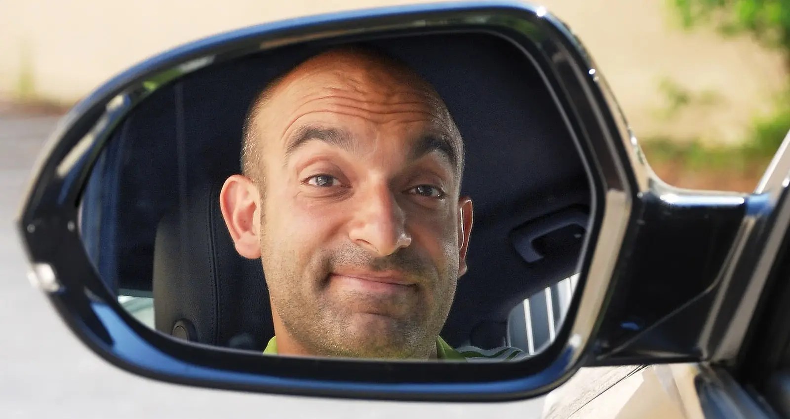 Django Asül reflektiert in einem Autospiegel