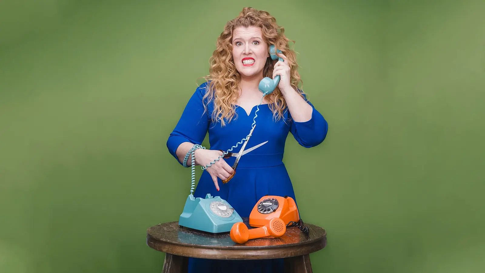 Franziska Wanninger mit Telefon in der Hand vor grünem Hintergrund – offizielles Veranstaltungsbild zum Kabarettprogramm „Wenn du wen brauchst, ruf mich nicht an“.