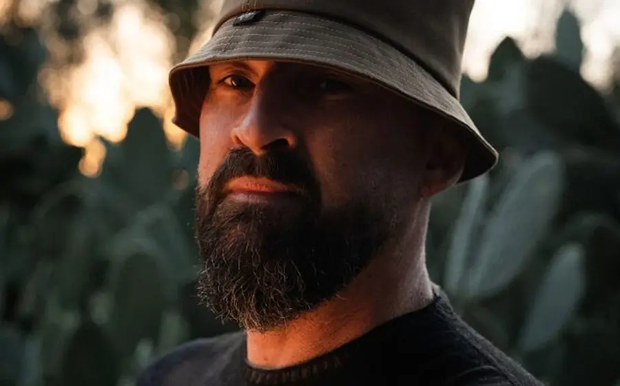Porträt des Reggae-Künstlers Gentleman mit Bart und Hut im Freien bei warmem Licht, Nahaufnahme vor unscharfem Hintergrund, Pressefoto zur Konzerttour.