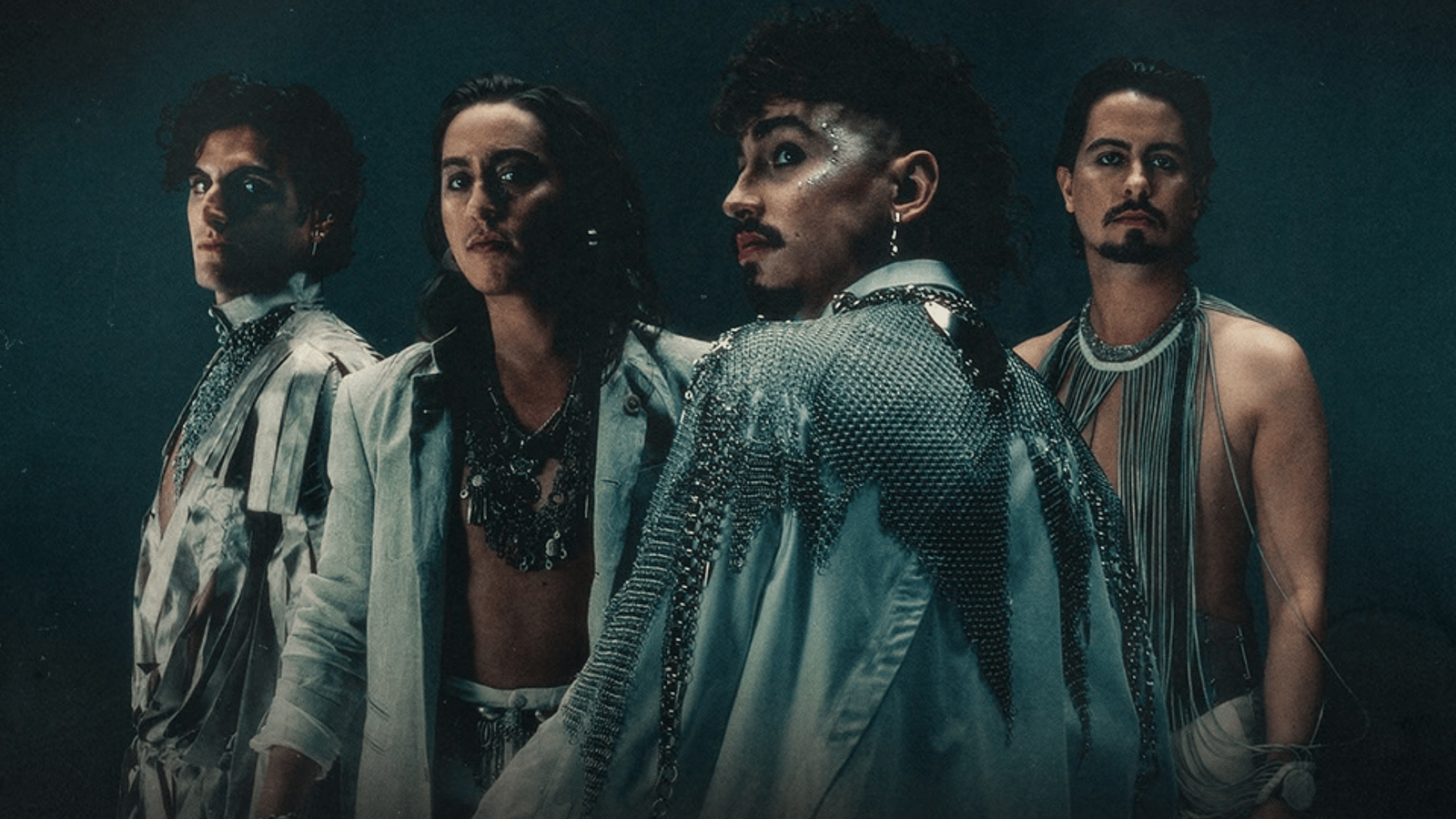 Die Band Greta Van Fleet ind aufallender Kleidung vor dunkel blauem Hintergrund
