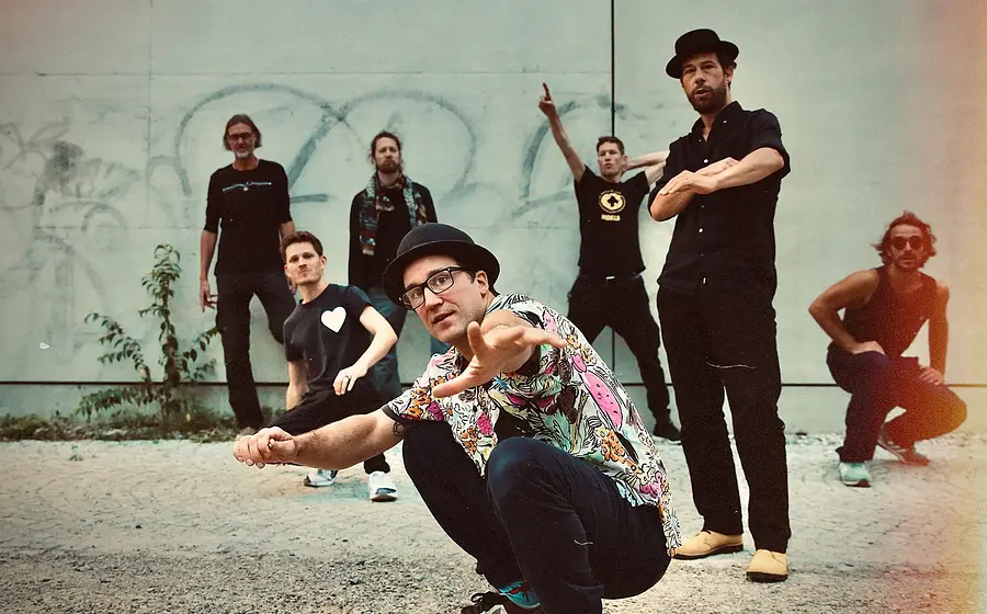 Die band vor einer Mauer mit Graffiti