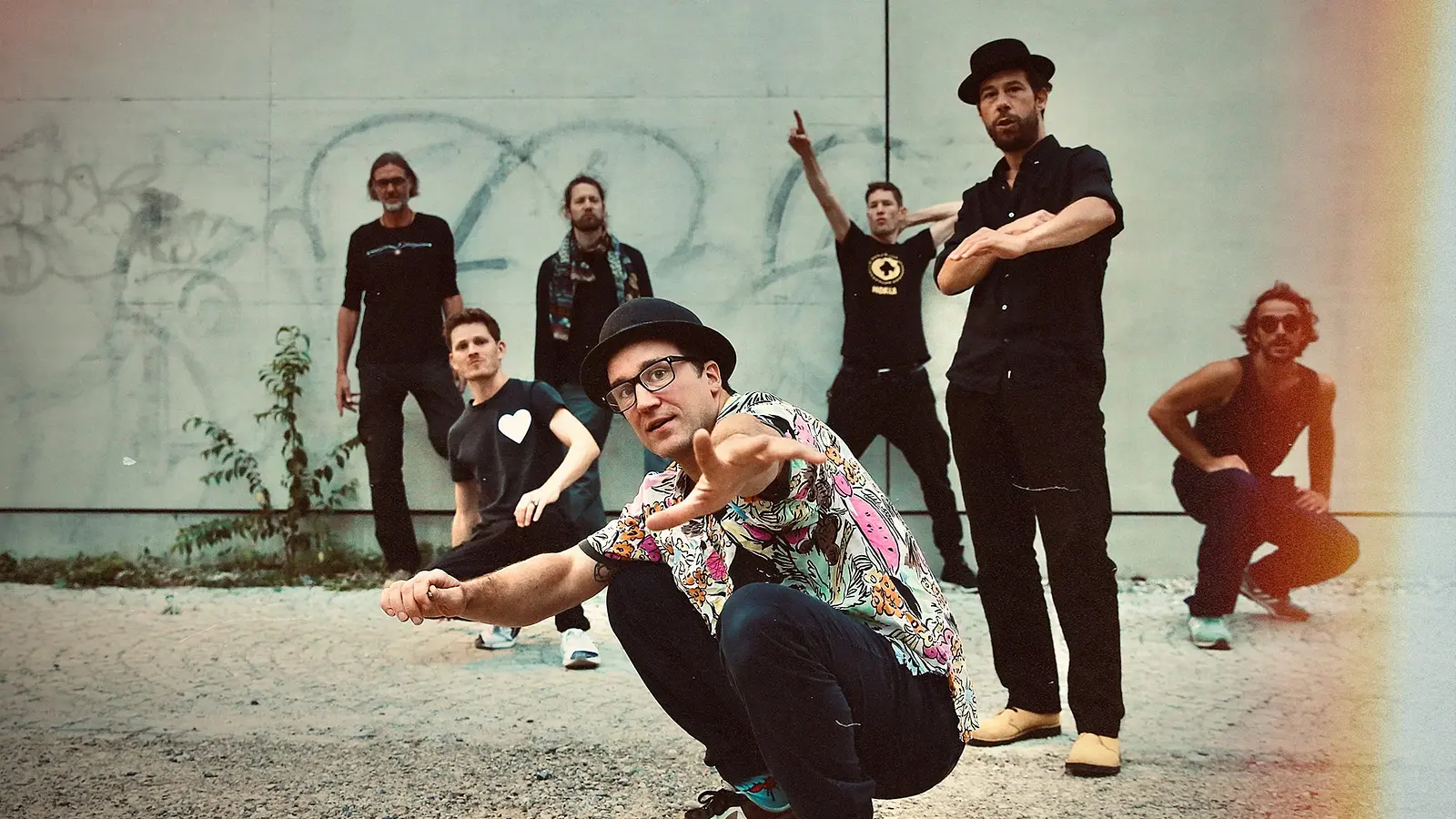 Die band vor einer Mauer mit Graffiti