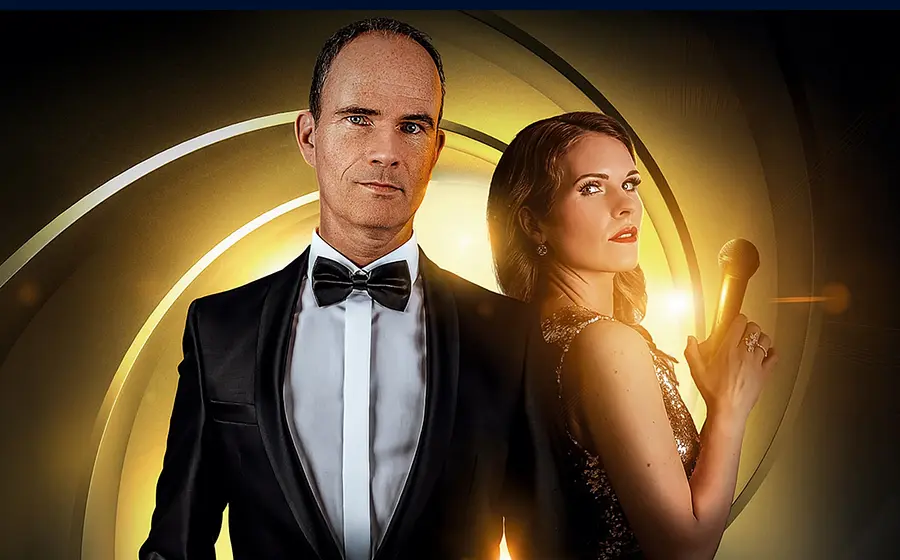 Plakat Skyfall mit zwei Personen in eleganter Abendgarderobe vor gold leuchtendem Hintergrund, eine Person im Smoking, die andere mit Mikrofon in der Hand, im Stil eines James-Bond-Filmplakats.