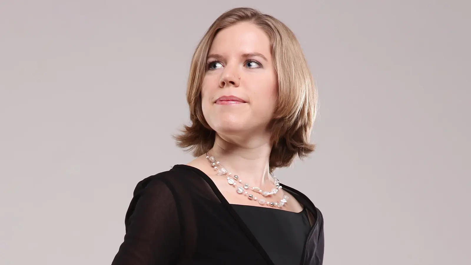 Porträt der Sopranistin Angelika Huber in schwarzer Kleidung vor hellem Hintergrund