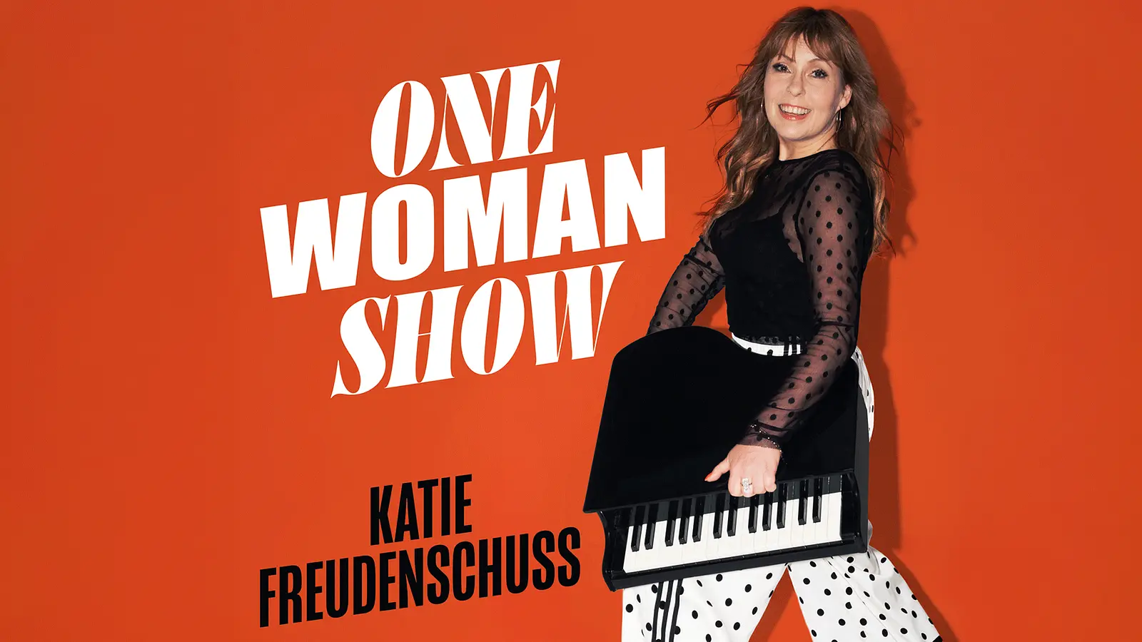 Poster der Kabarettistin Katie Freudenschuss vor orangefarbenem Hintergrund sie hält ein tragbaren Flüge mit den Aufschriften One Woman Show und Katie Freudenschuss links neben ihr