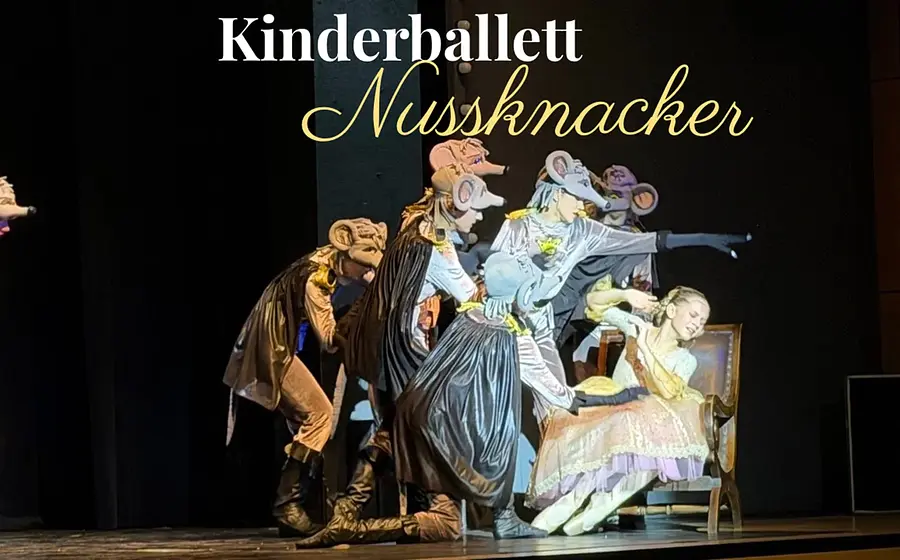 Ein Bühnenbild mit Rewuisiten und den Darstellern des Kindeballetts sowie Aufschrift des Titels