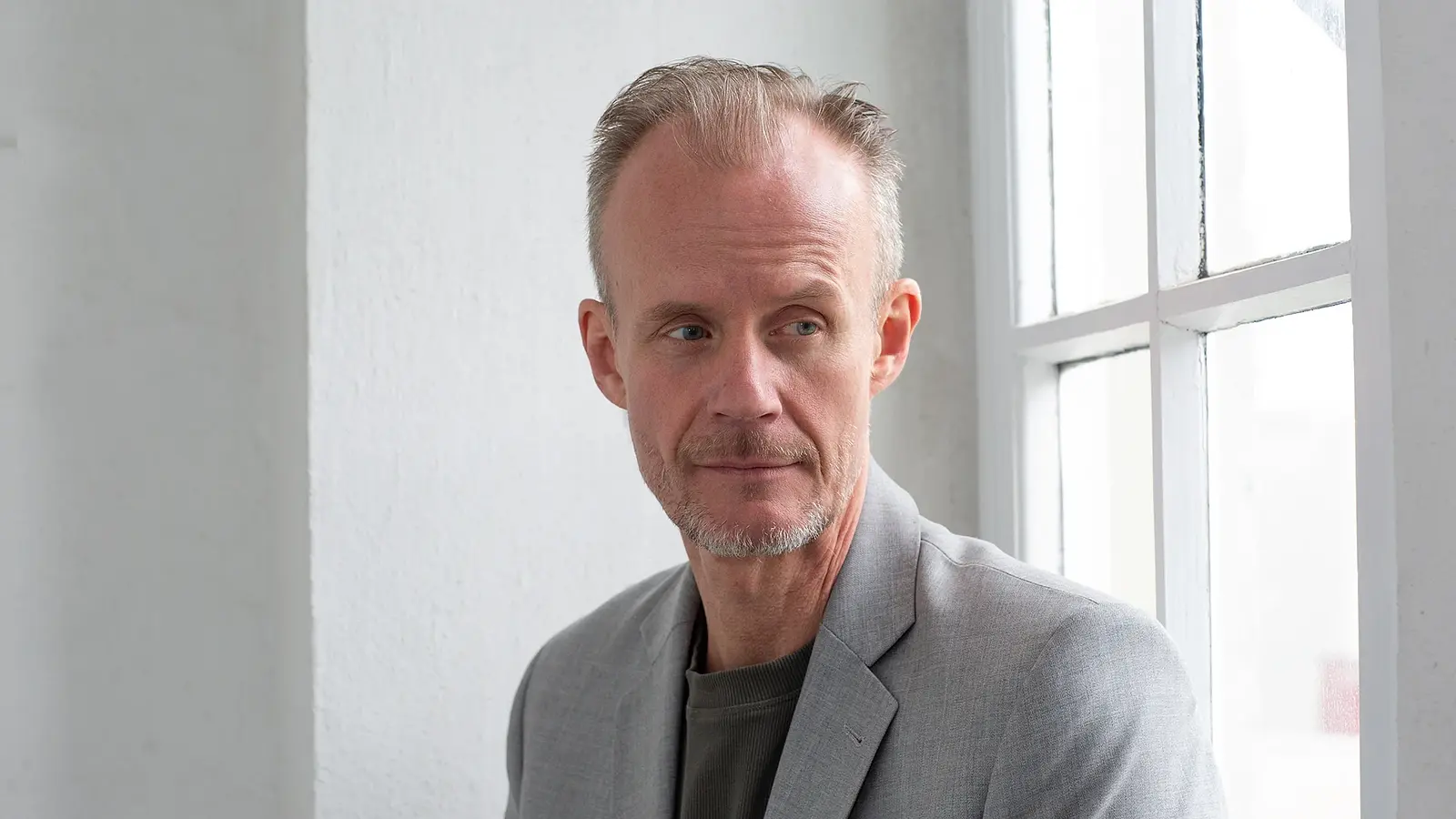 Portrait des Künstlers vor enem weißen Fenster