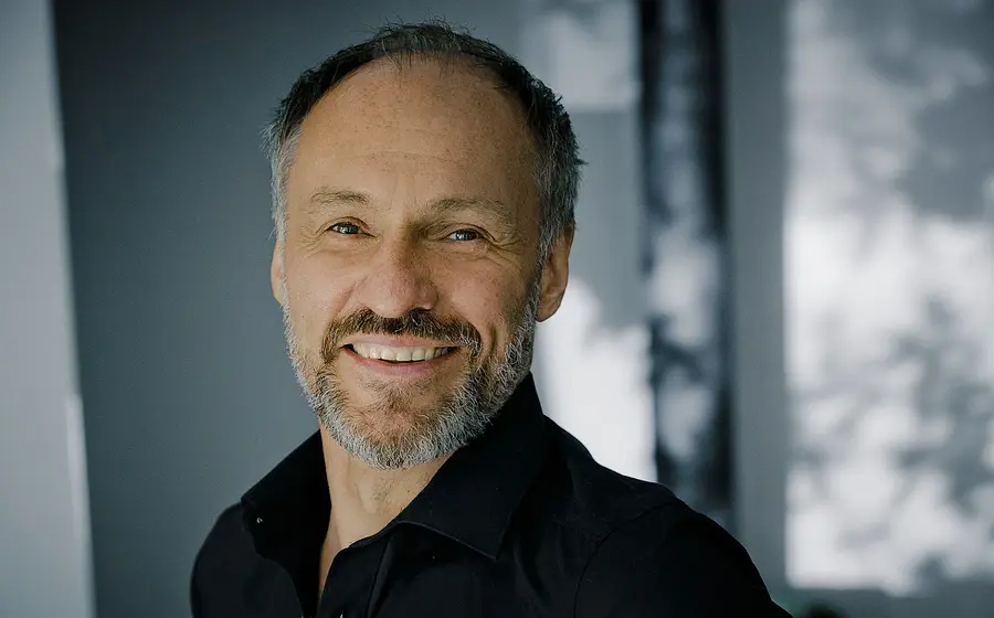 Portrait von Armin Stockerer in schwarzem Hemd vor verschwommenem Hintergrund