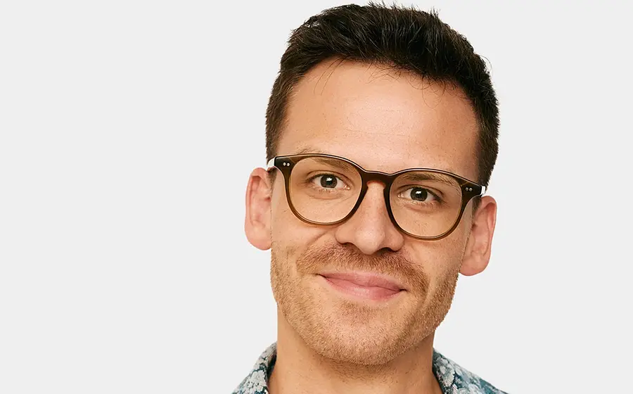 Porträt von Martin Frank einer lächelnd mit Brille vor hellem Hintergrund.