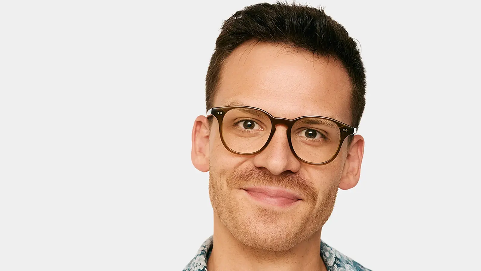 Porträt von Martin Frank einer lächelnd mit Brille vor hellem Hintergrund.