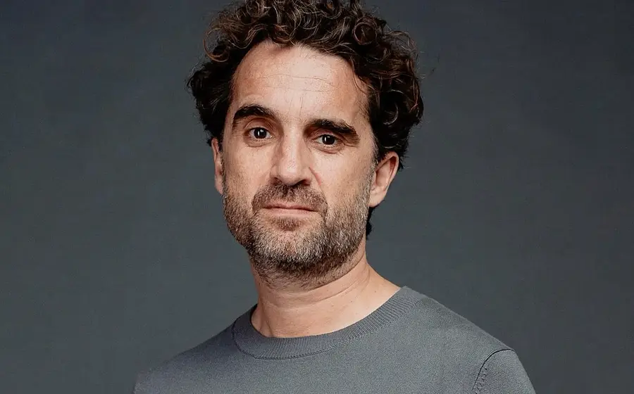Ein Portrait von Oliver Wnuk in grauem Pullover und grauem Hintergrund