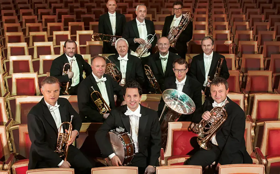 Das Brass-Ensemble auf den Besuchersitzen in dunklen Anzügen und mit Instrumenten