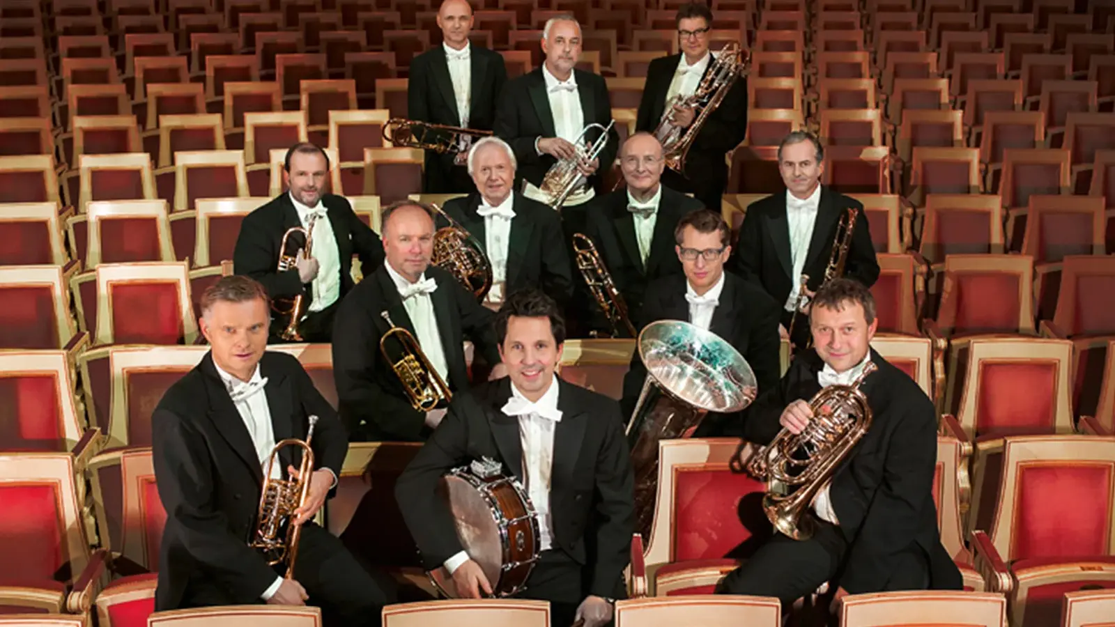 Das Brass-Ensemble auf den Besuchersitzen in dunklen Anzügen und mit Instrumenten