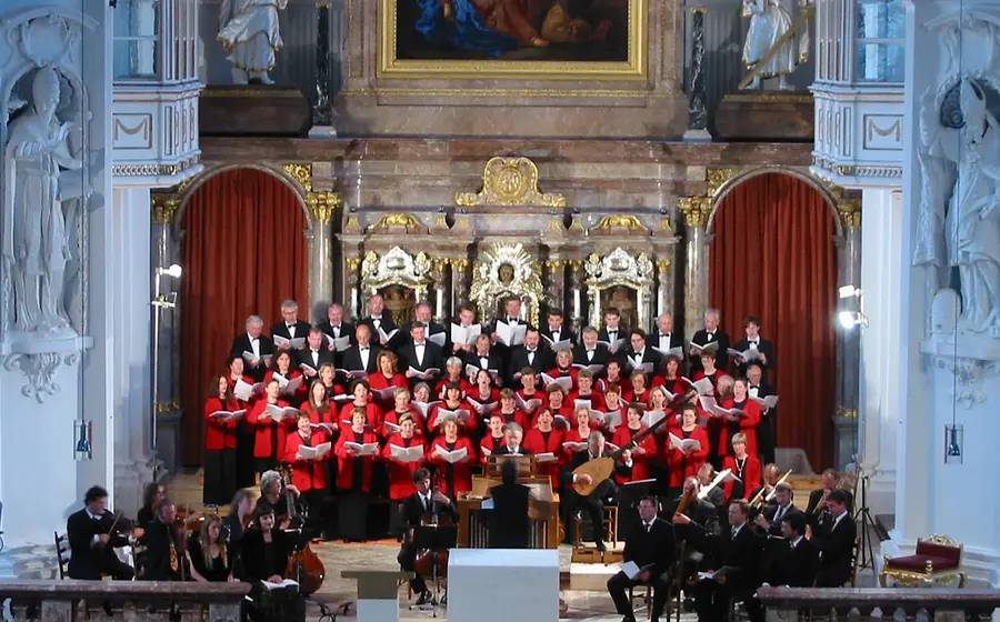 Foto für die Veranstaltung ‚St. Quirinus Konzerte Tegernsee‘ mit einem Chor, der in einer Kirche singt