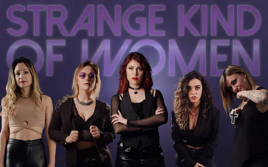 Die fünf Musikerinnen der Band Strange Kind Of Women in schwarzer Kleidung vor violettem Hintergrund