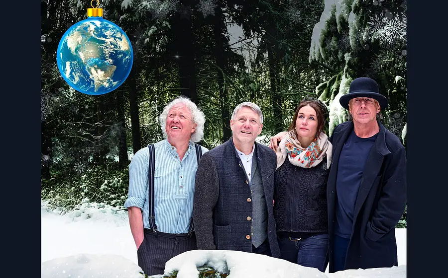 Plakat mit vier Personen in winterlicher Waldlandschaft, die zu einer großen blauen Christbaumkugel in Form der Erde aufblicken, vor verschneiten Bäumen