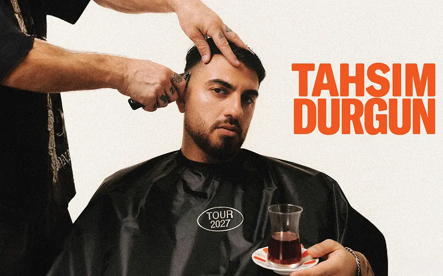 Plakat von Tahsim Durgun beim Haareschneiden, sitzend mit Friseurumhang und Teeglas in der Hand, daneben der Schriftzug Tahsim Durgun und Tour 2027
