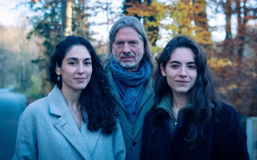 Das Ensemble Phoenix Munich mit drei Personen in Herbstkleidung auf einem Waldweg, vor herbstlich gefärbten Bäumen und unscharfem Hintergrund.