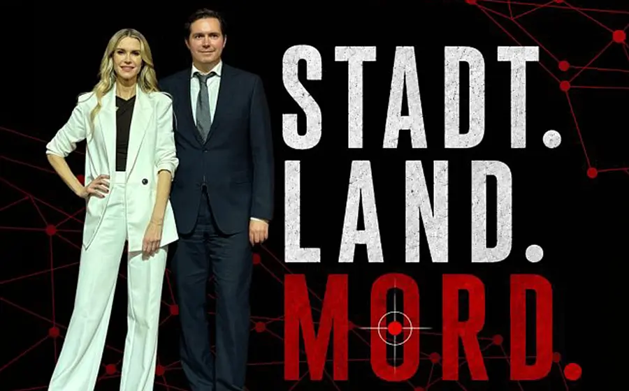 Poster mit den Aufschriften Stadt. Land. Mord. Eine Person in hellem Hosenanzug und die andere in einem dunklem Anzug stehen vor schwarzem Hintergrund mit rotem Netzwerkmuster und Fadenkreuzsymbol im Schriftzug.