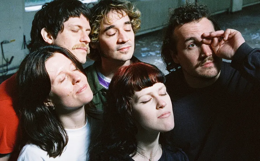Die fünf Mitglieder der Band Tramhaus stehen zusammen und halten die Köpfe mit geschlössenen Augen nach oben