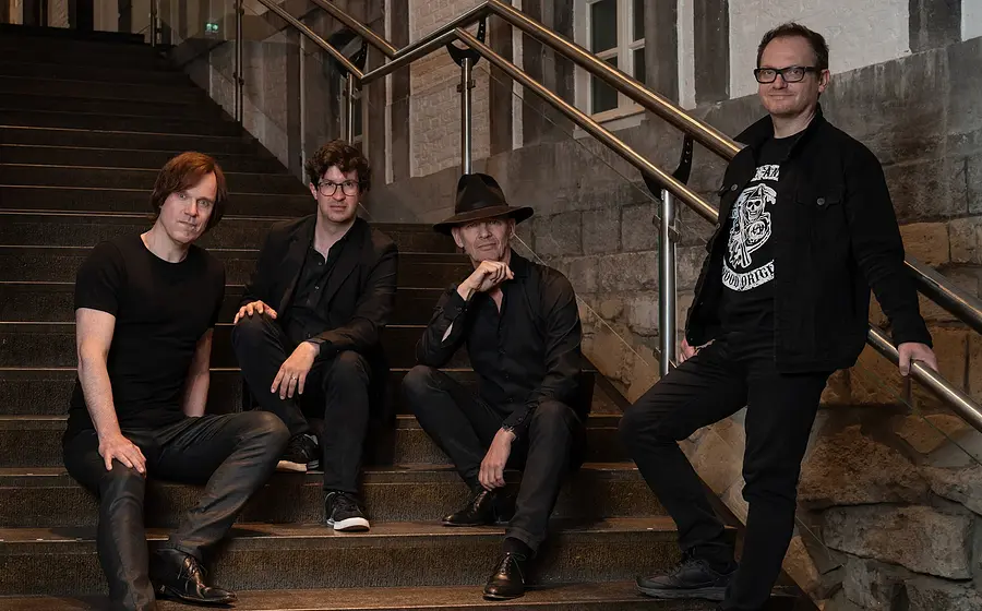 Foto für die Veranstaltung Vokal Total – Rock4, mit den Künstlern, die auf einer Treppe sitzen