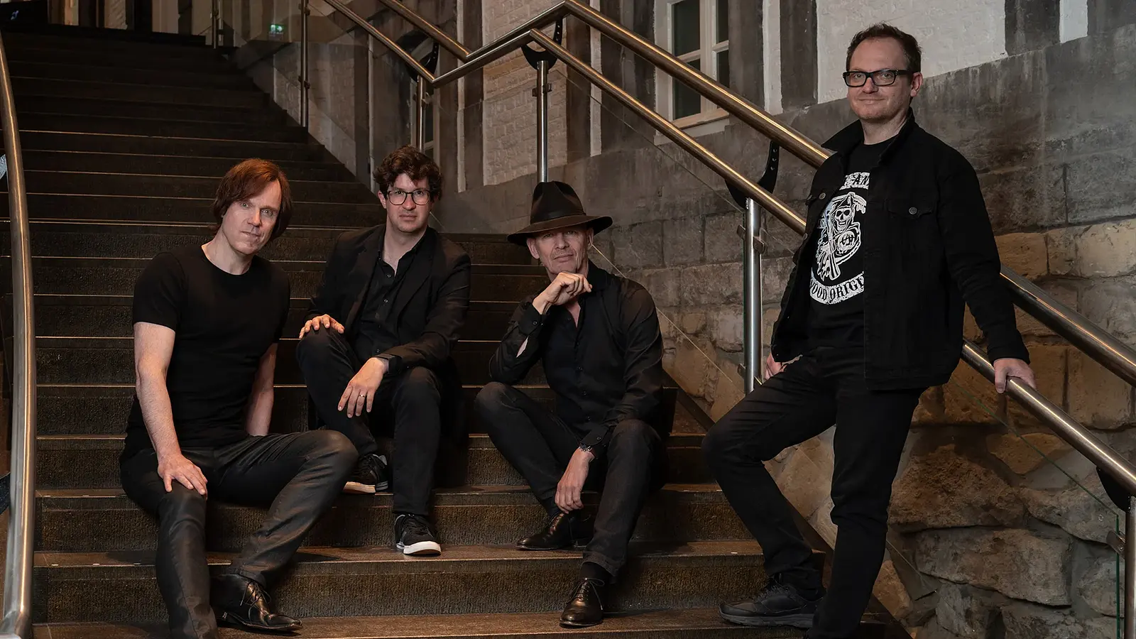 Foto für die Veranstaltung Vokal Total – Rock4, mit den Künstlern, die auf einer Treppe sitzen