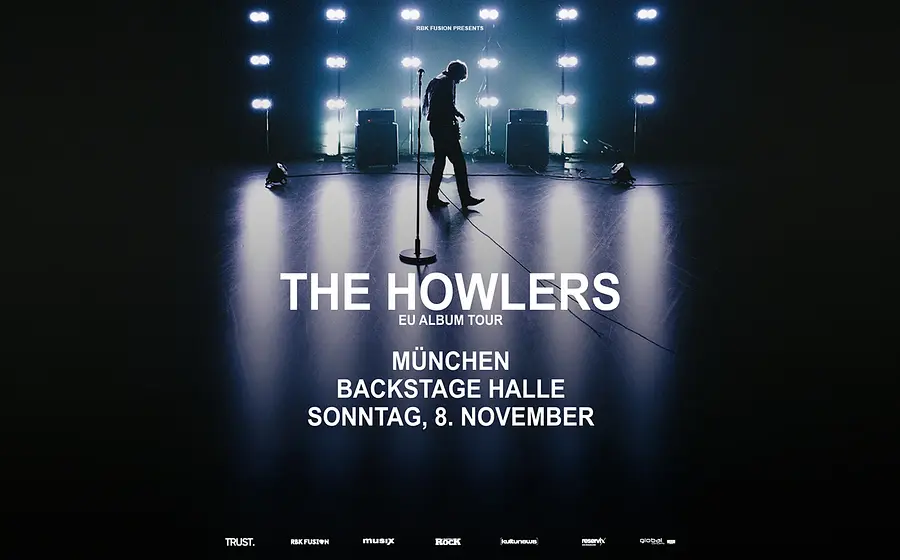 Dunkles Konzertmotiv mit der Silhouette eines Musikers auf einer beleuchteten Bühne sowie den Veranstaltungsdetails zur EU Album Tour von The Howlers in der Backstage Halle München.