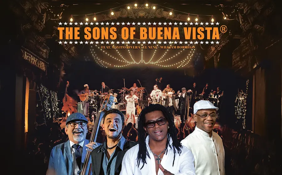 Bandfoto von The Sons of Buena Vista vor einer Konzertbühne mit mehreren Musikern und beleuchtetem Hintergrund.