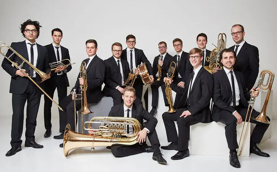 Gruppenfoto des Blechbläserensembles Salaputia Brass mit Instrumenten vor hellem Hintergrund, Werbebild zum Konzert „Winterzauber“ von Salaputia Brass.