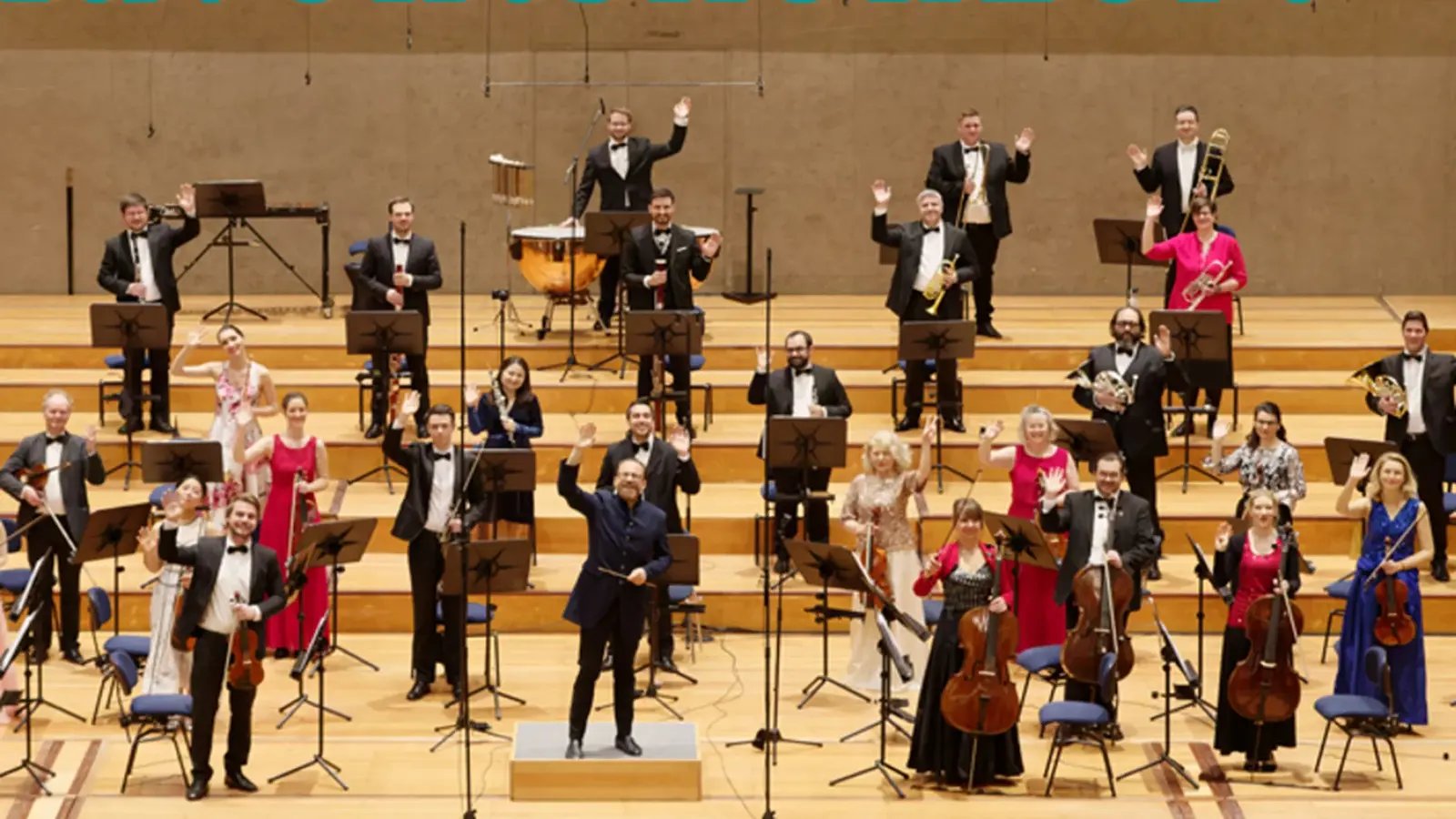 Ein Orchester mit Instrumenten  auf einer breiten Bühne mit Treppen während einer Vorführung