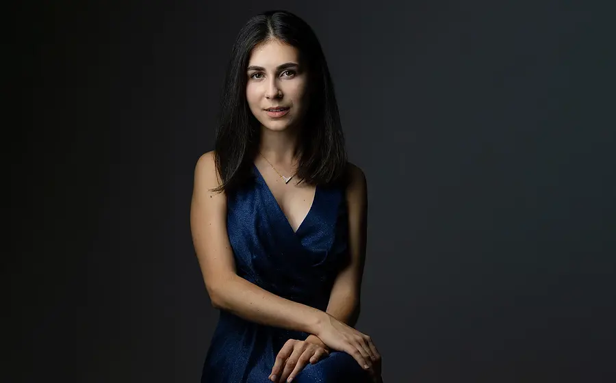 Porträt der Pianistin Alexandra Dovgan vor dunklem Hintergrund.