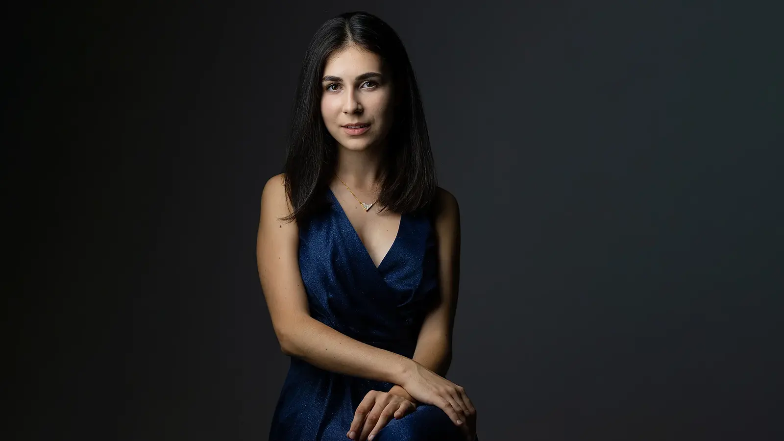 Porträt der Pianistin Alexandra Dovgan vor dunklem Hintergrund.