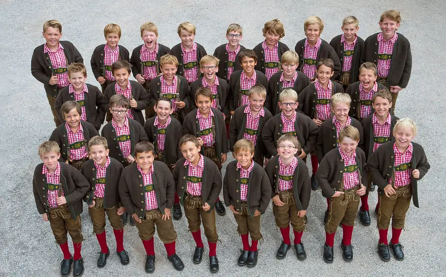 Gruppenbild des Tölzer Knabenchors in Tracht mit karierten Hemden und Lederhosen