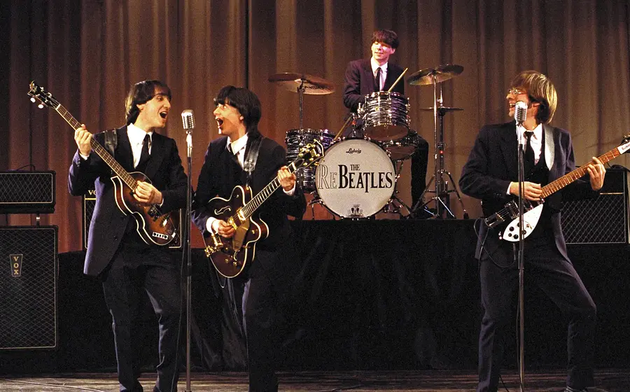 Die Re-Beatles auf der Bühne vor einem braunen Vorhang