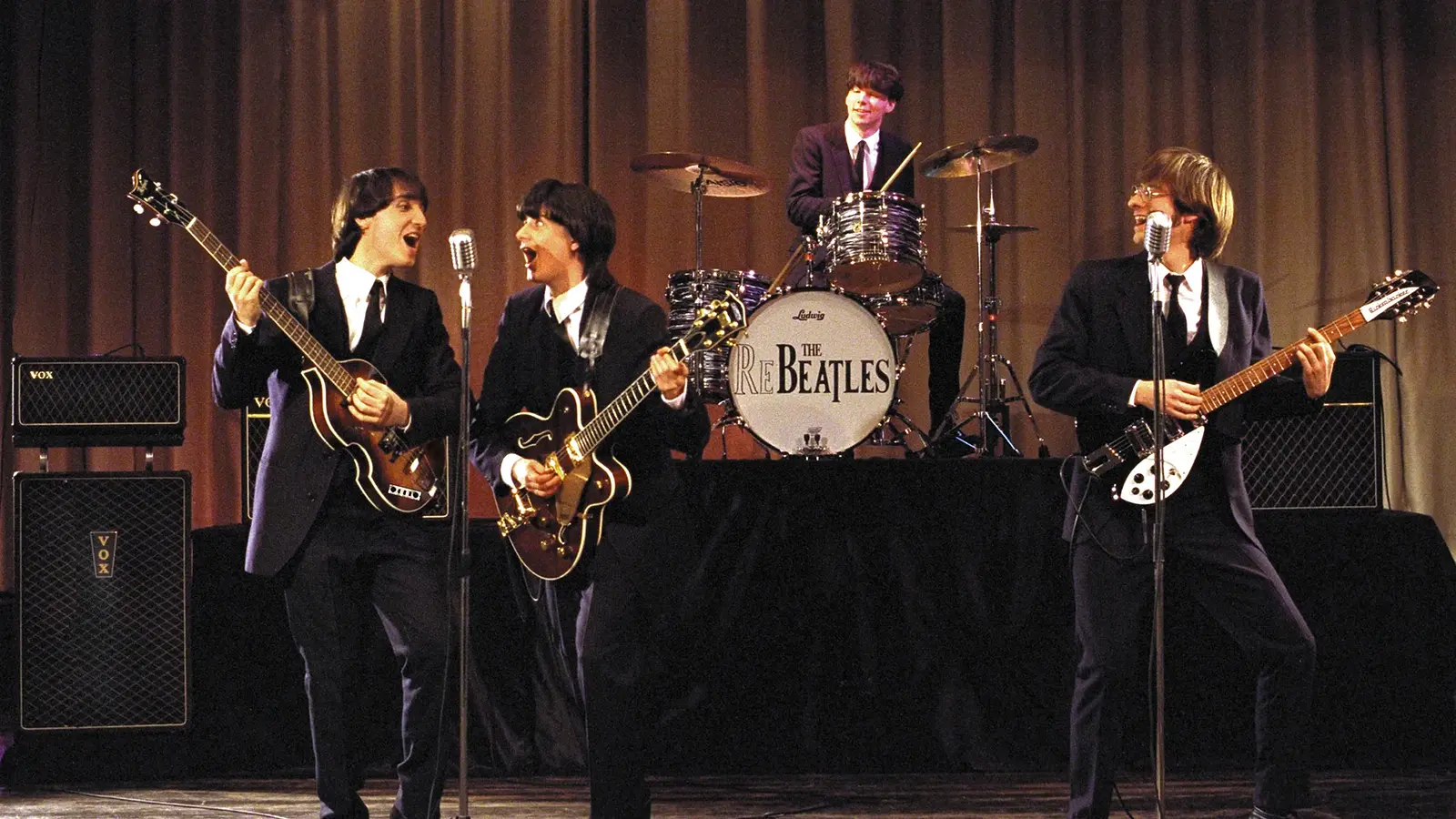 Die Re-Beatles auf der Bühne vor einem braunen Vorhang