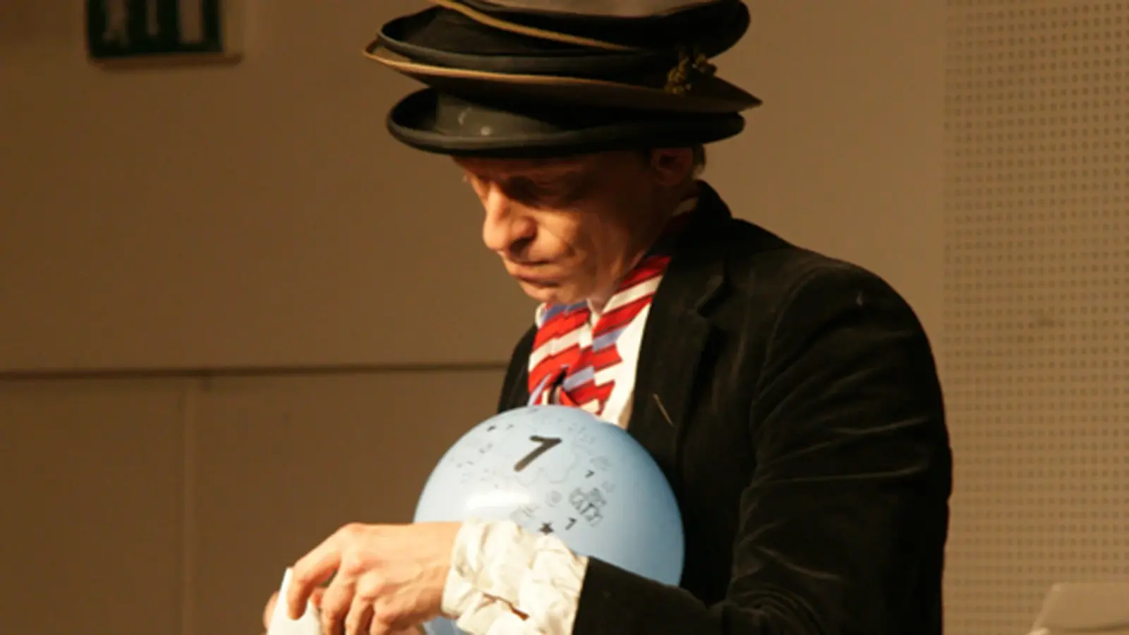 Foto von der Veranstaltung „Die Ver(w)irrung des Nepermuk Semmelmeier“ mit einem Ball und mehreren Hüten, die übereinander gestapelt sind.